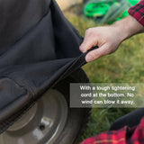 A person grips a bag with a mower cover inside, highlighting its protective features for outdoor equipment.